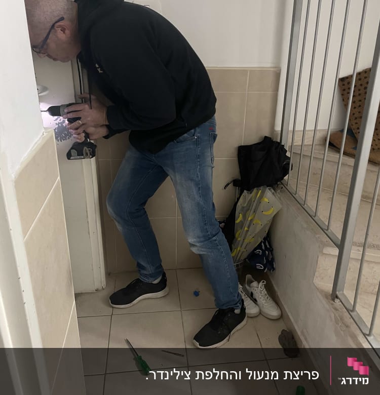 אדם קודח בדלת עם מקדחה חשמלית
